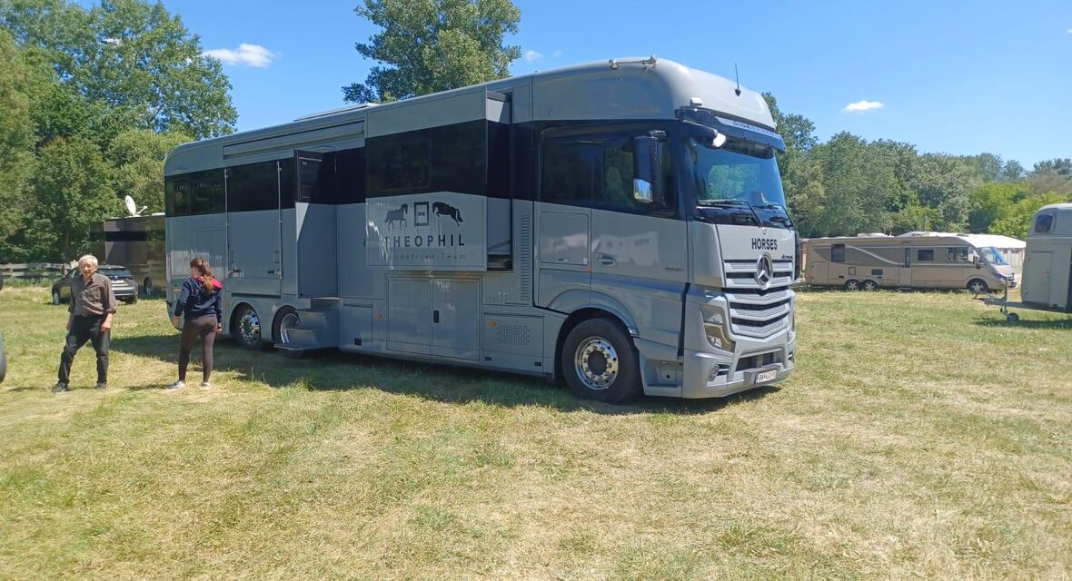 Pferde-LKW zwischen Fahrzeugen auf einem Turniergelände